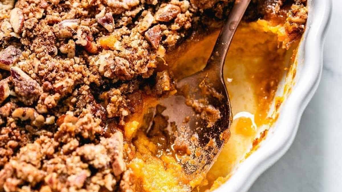 A spoonful of sweet potato crumble in a white dish.