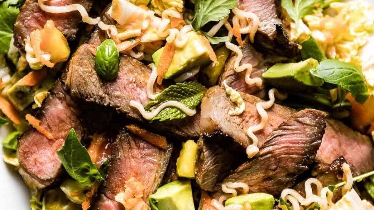 A plate with a steak salad on it.