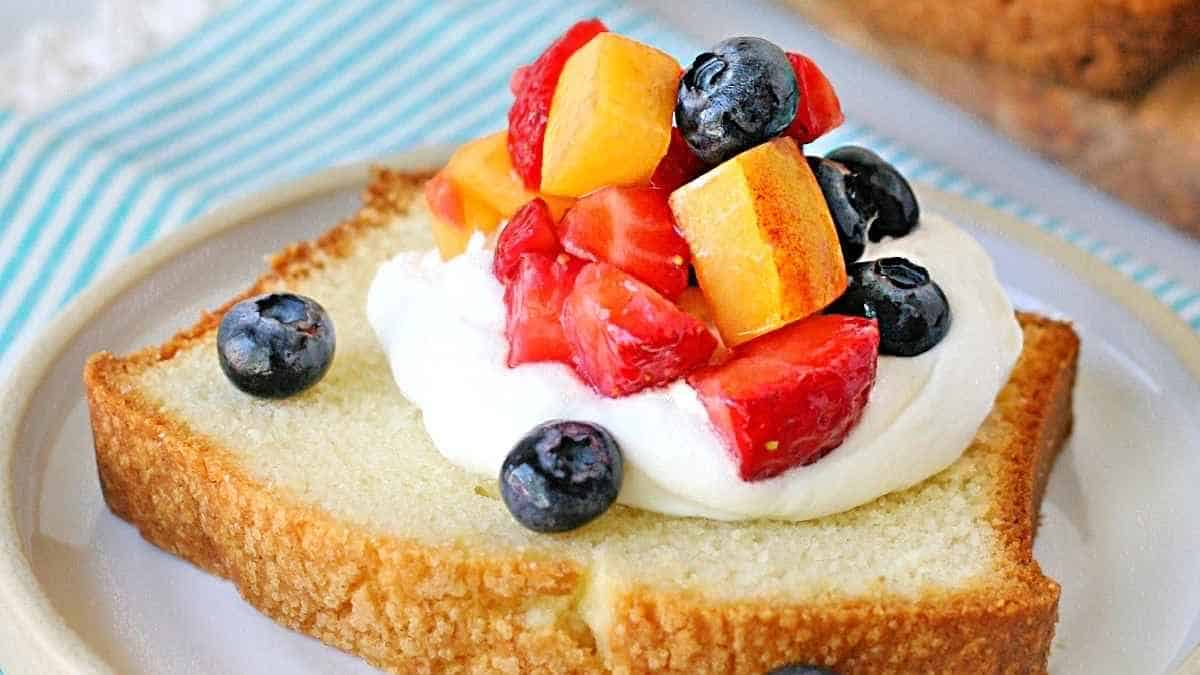 A slice of bread topped with fruit and whipped cream.