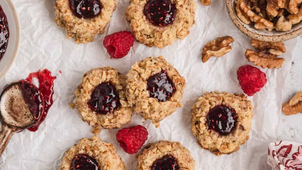 A group of cookies with raspberries and nuts.