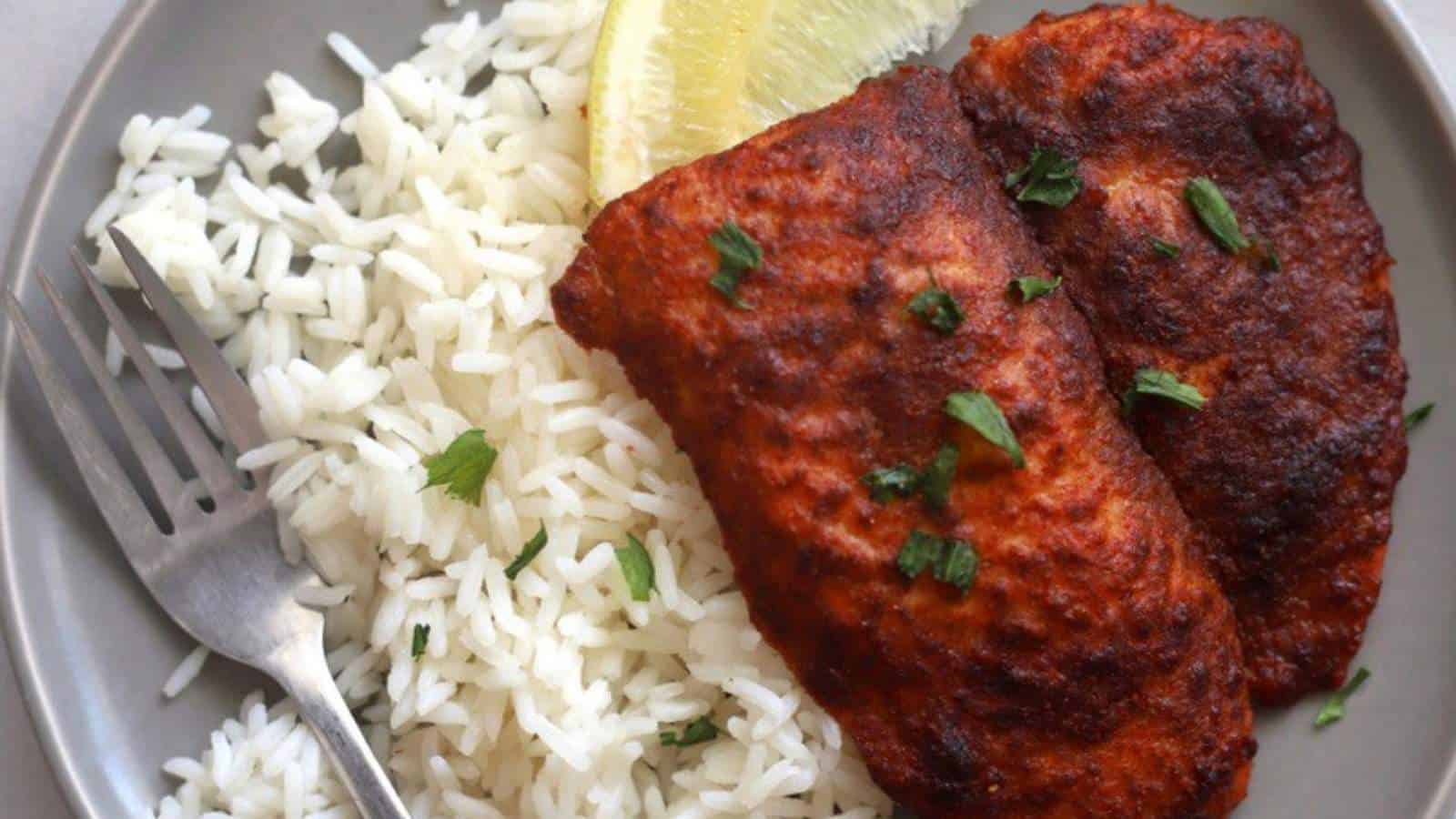 A plate with rice and chicken on it.