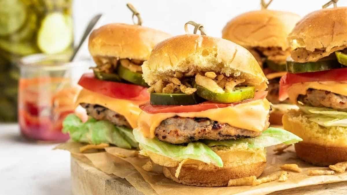 Burger sliders on a wooden cutting board.