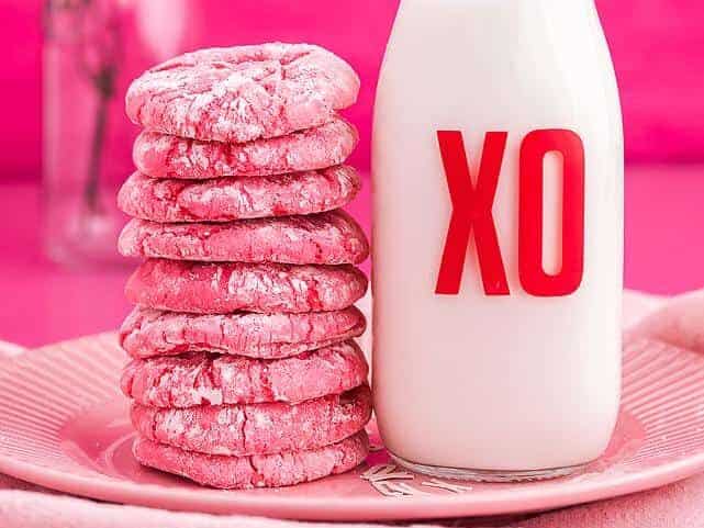 Valentine's day cookies and milk on a pink plate.
