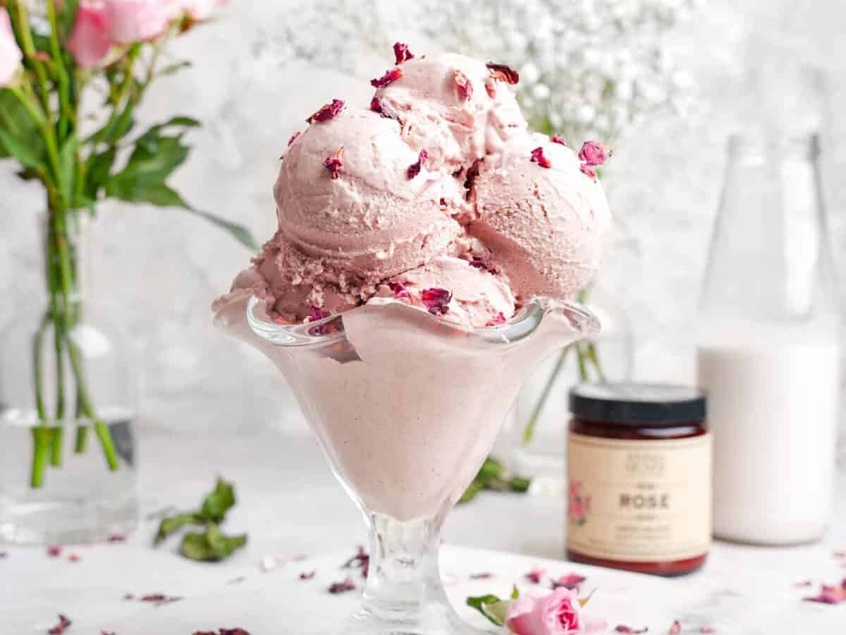 A bowl of ice cream with rose petals on it.