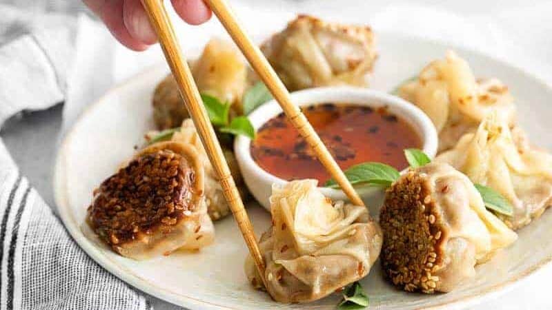 Dumplings on a plate with chopsticks.