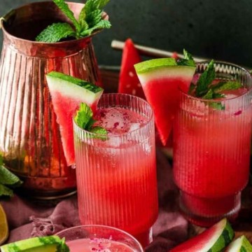 Watermelon cocktail with mint leaves on a tray.