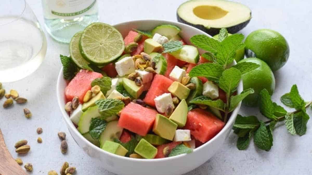A bowl of watermelon salad with lime and pistachios.
