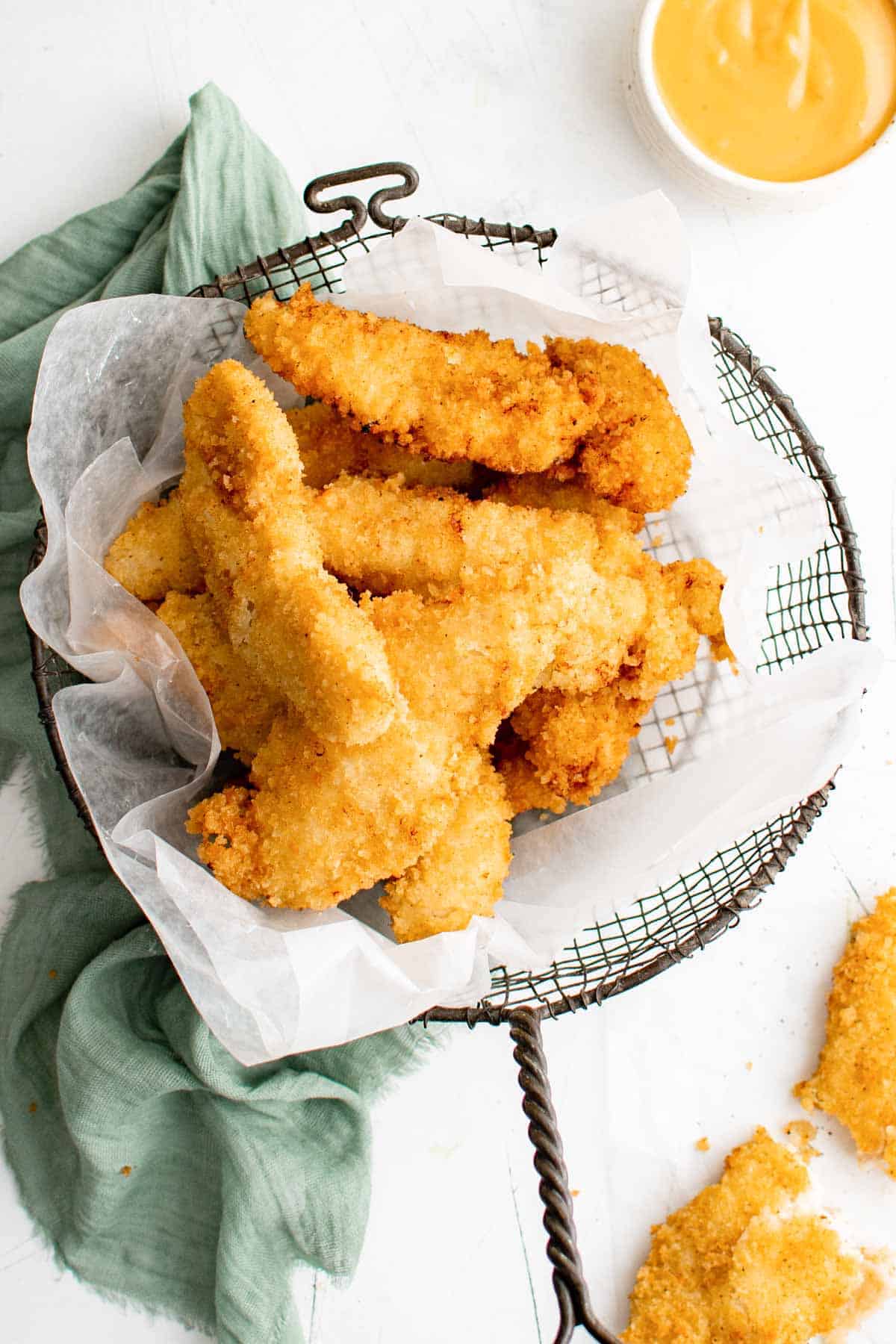 Fried fish sticks in a basket with delicious dipping sauce.