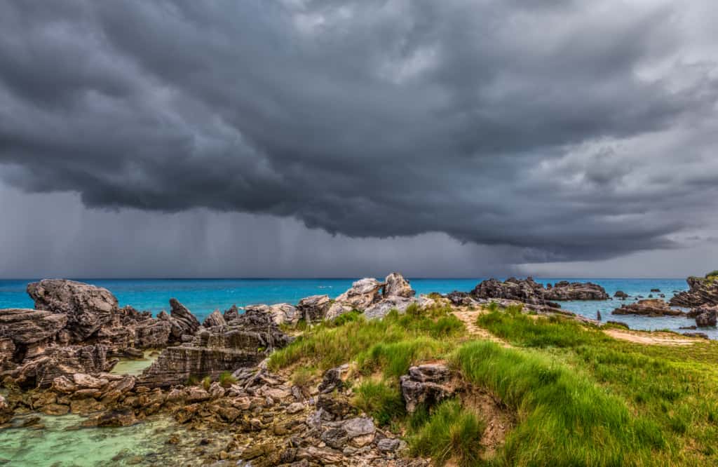آسمان طوفانی بر فراز یک ساحل صخره ای و اقیانوس.