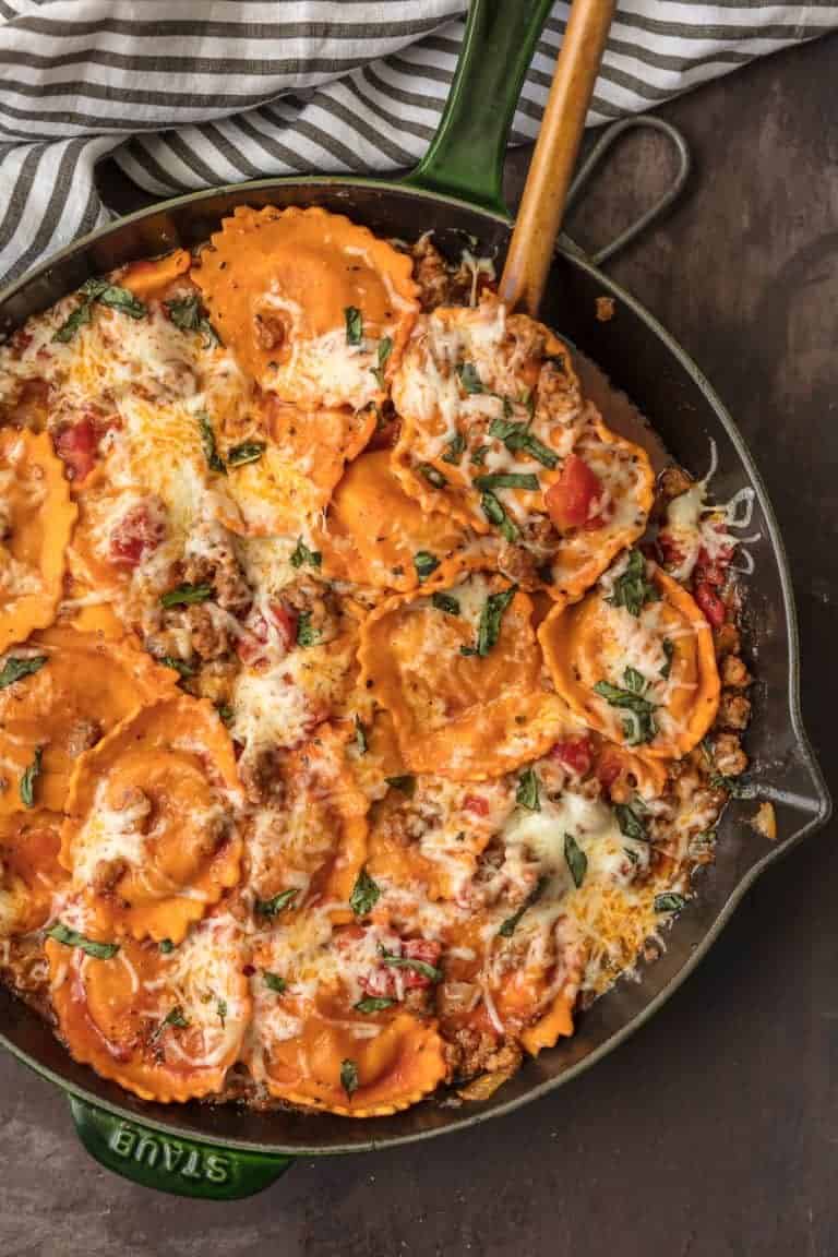 A sausage-filled skillet with ravioli in tomato sauce.