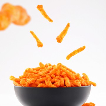 Cheesy chips in a bowl on a white background.