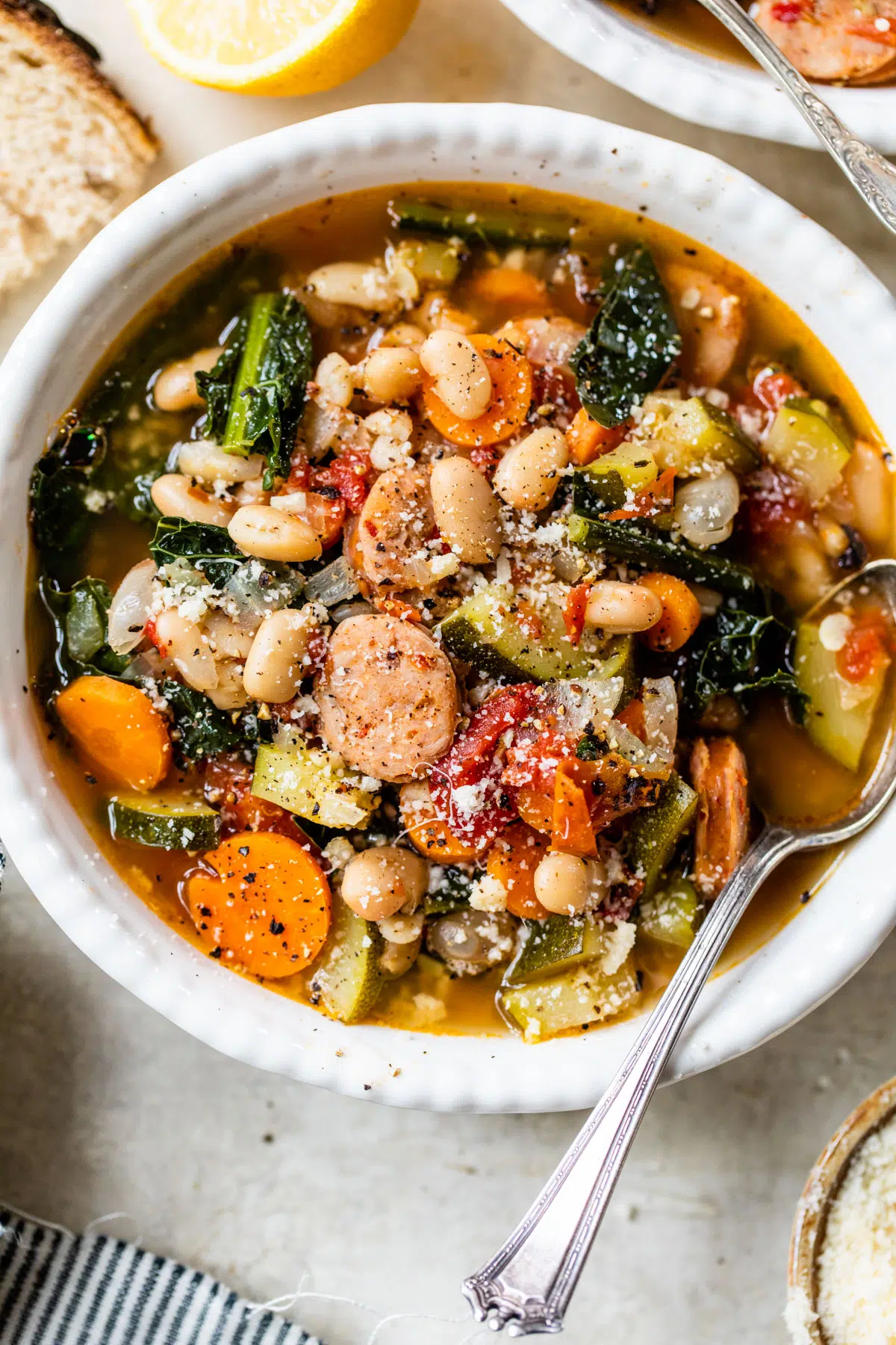 A delicious bowl of sausage soup with beans and vegetables.