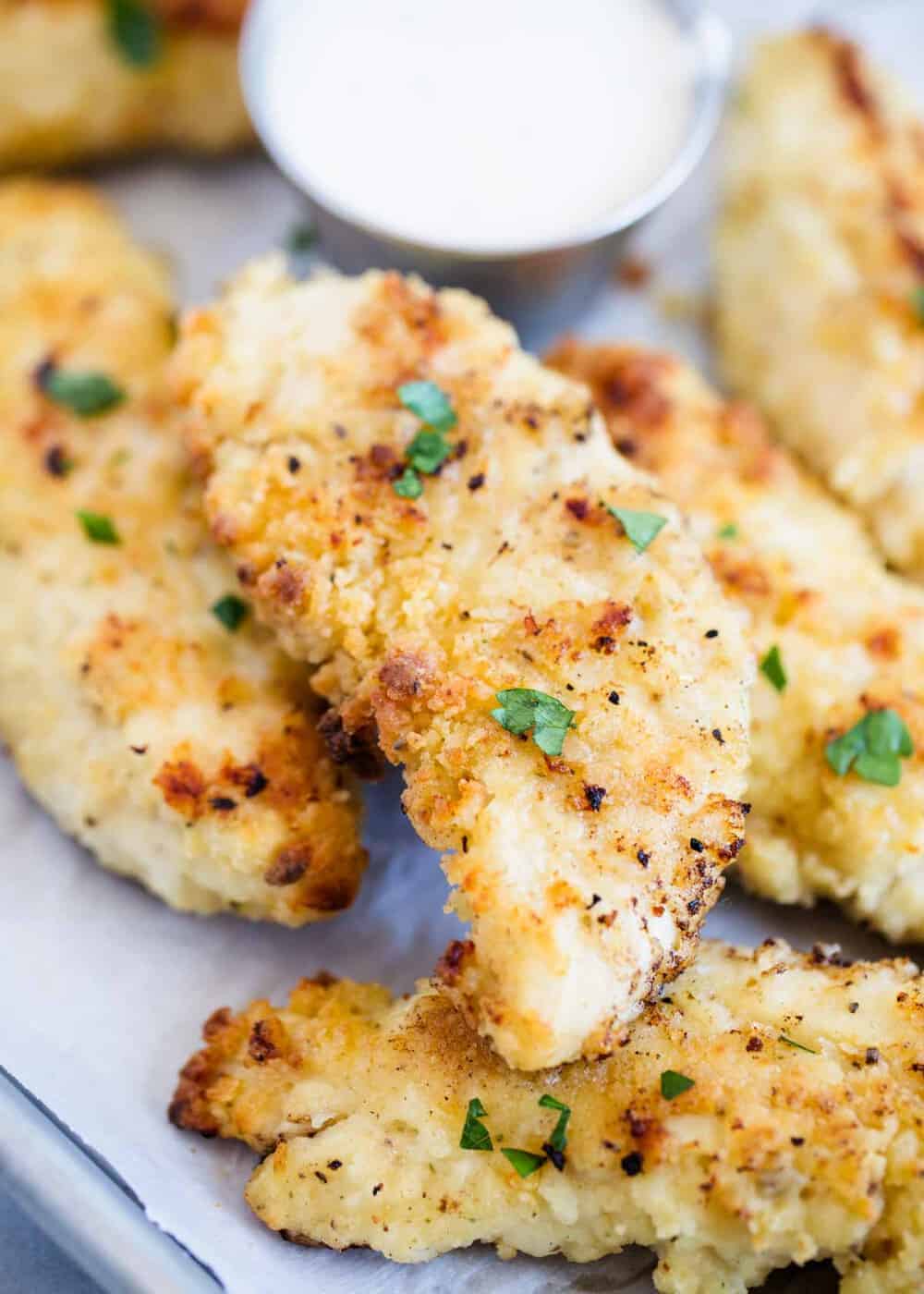 Delicious and crispy chicken tenders, prepared on a baking sheet alongside a lip-smacking dipping sauce. Perfect for those seeking easy chicken tender recipes to satisfy their cravings.