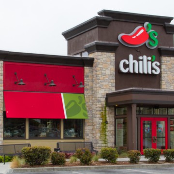 A chili's restaurant with red and green awnings that offers a gluten-free menu.