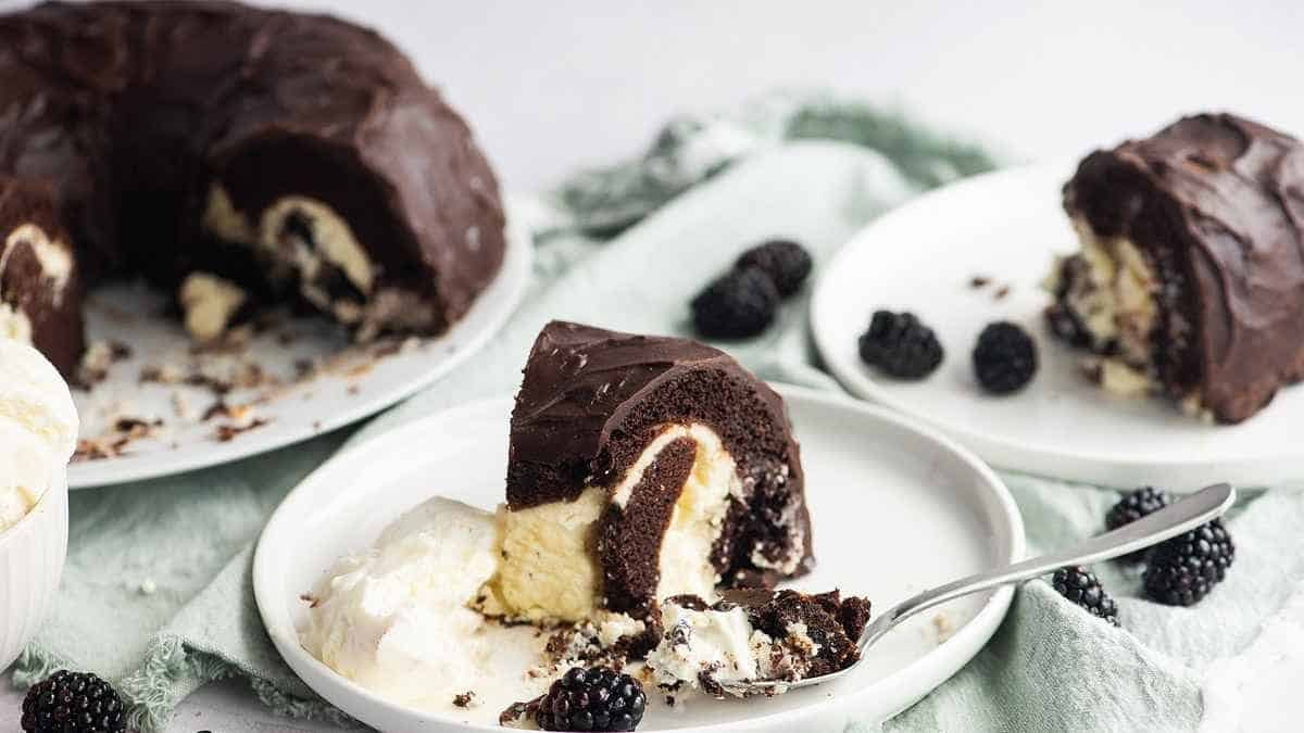 A chocolate bundt cake with whipped cream and blackberries.