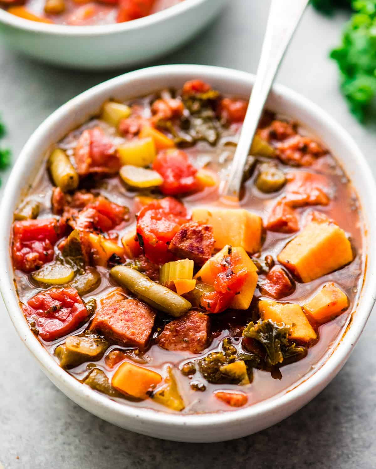 A flavorful bowl of stew made with sausage and a variety of vegetables.