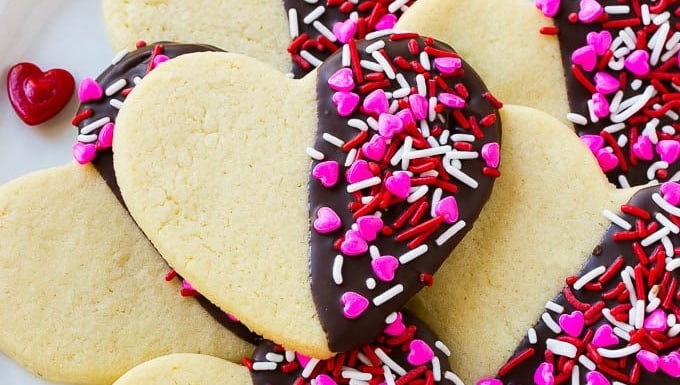 Valentine's day cookies on a plate with sprinkles.