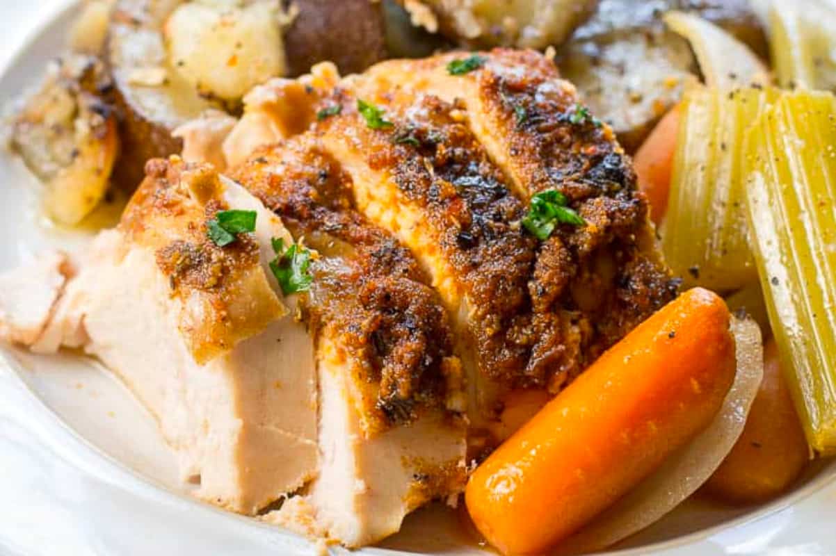 A plate of roasted chicken with carrots and potatoes.