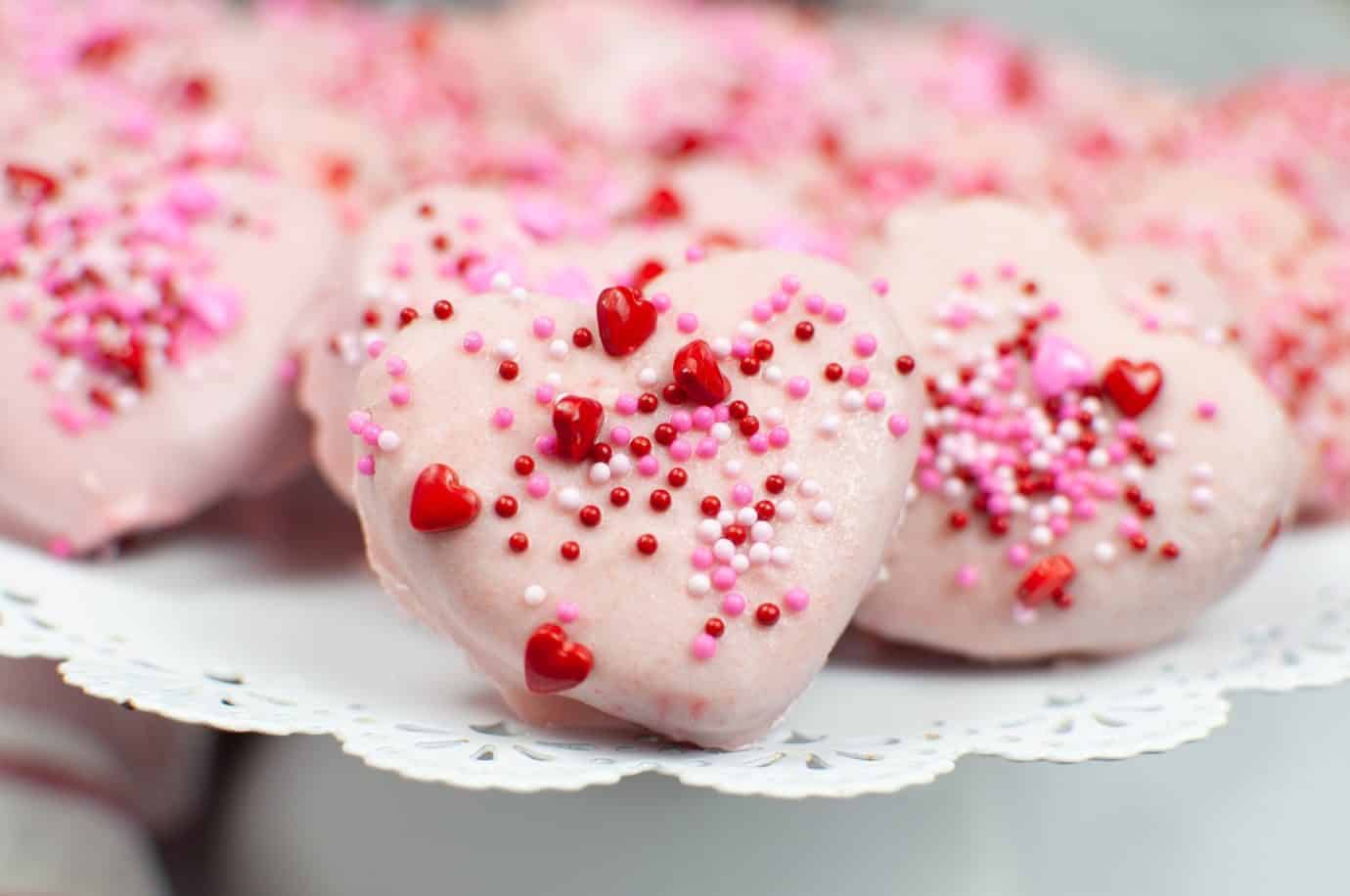 Valentine's day cookies with sprinkles on a plate.
