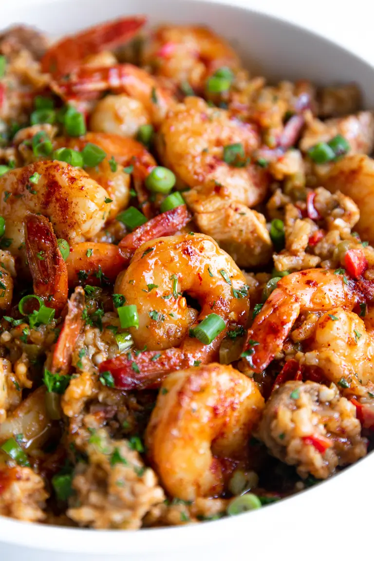 Shrimp and rice with sausage in a white bowl.