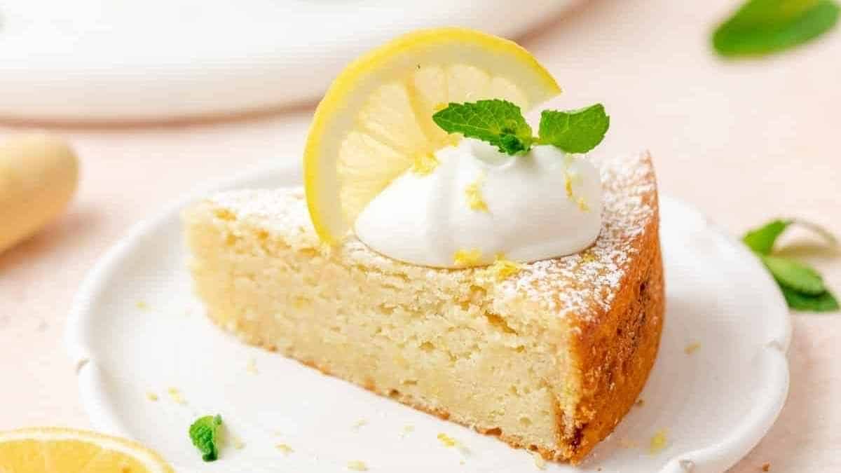 یک تکه کیک لیمو روی یک بشقاب سفید.