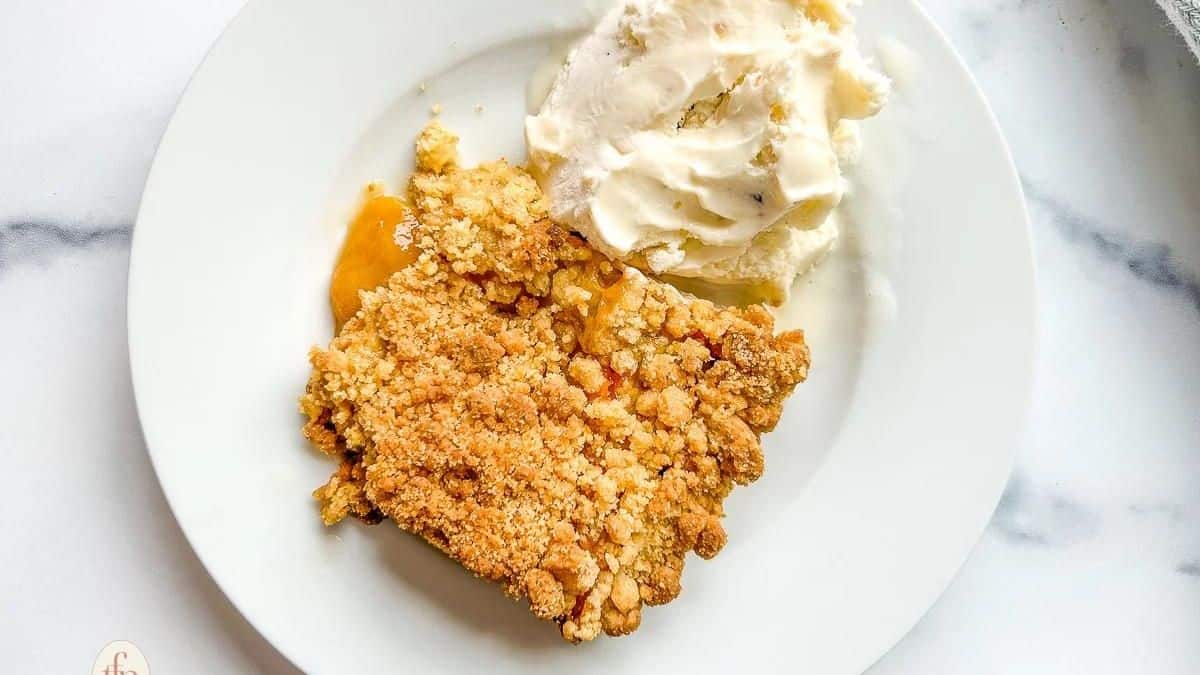 A plate with a piece of apple crisp and ice cream.