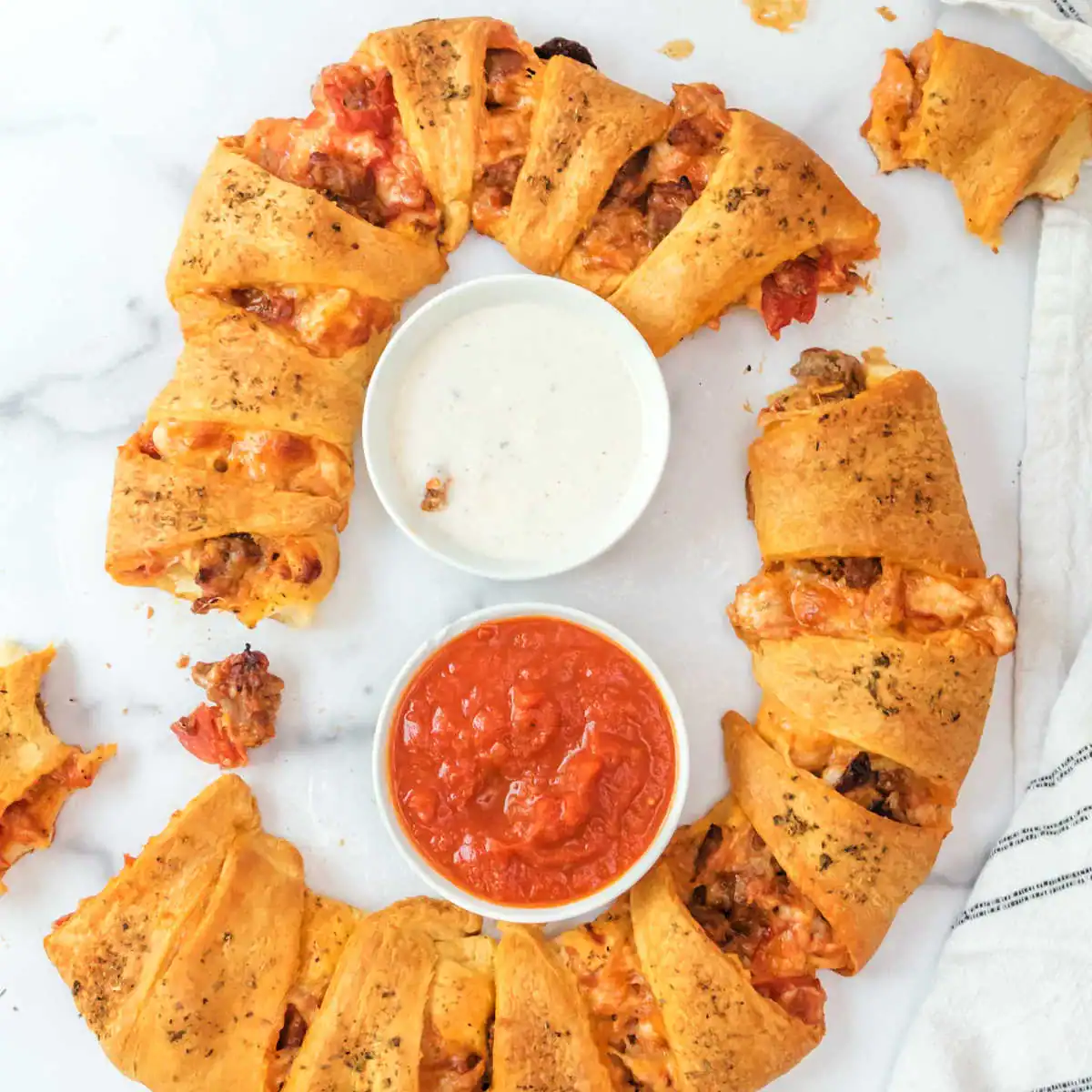 A ring of ground sausage recipes with sauces in the middle.