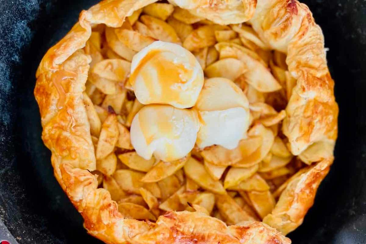 A pie filled with apples and eggs in a skillet.