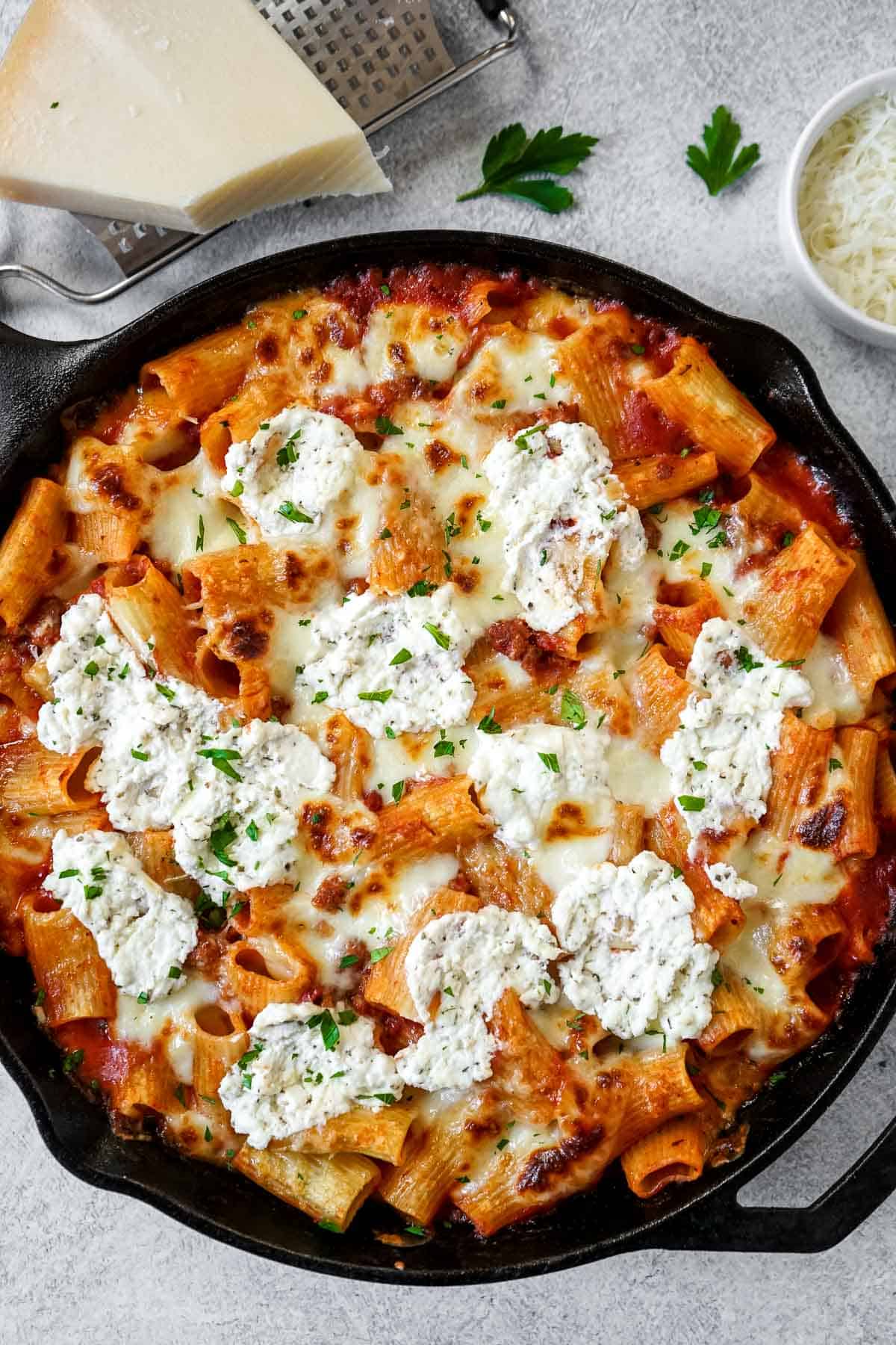 A skillet filled with ground sausage pasta and cheese.