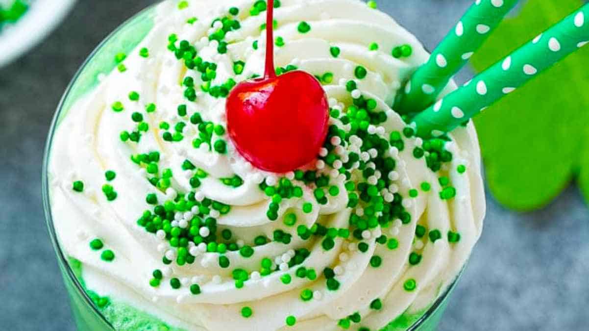 A st patrick's day drink with green icing and a cherry on top.