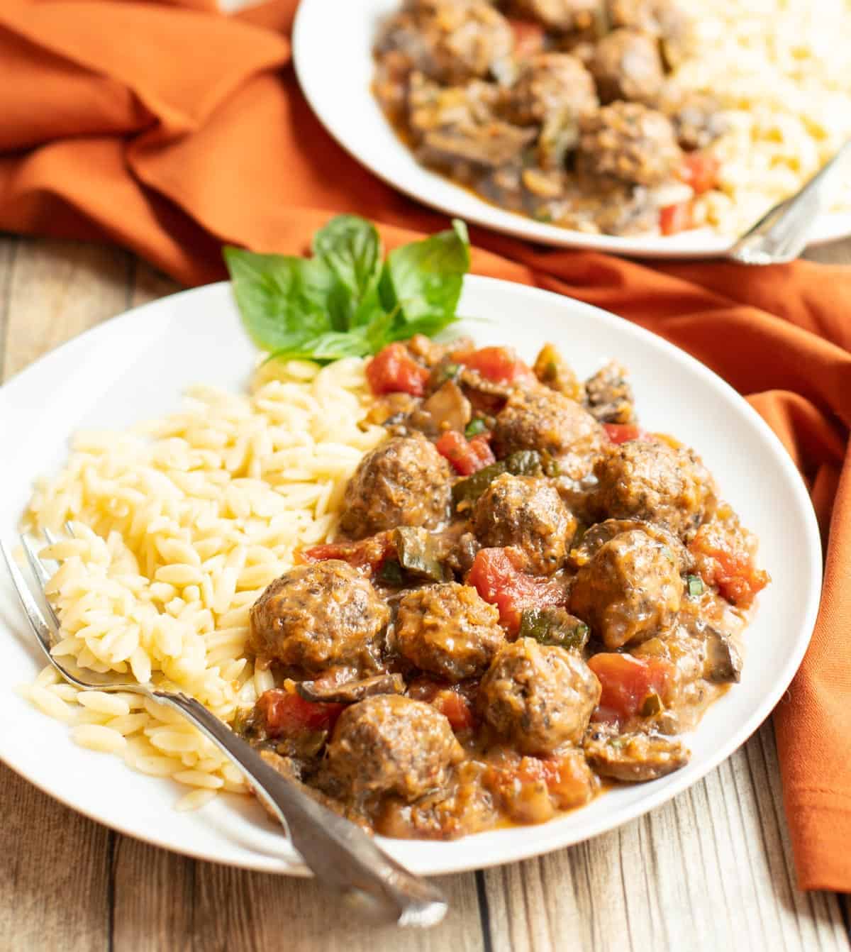 Delicious meatballs made with ground sausage, served in a rich tomato sauce on a plate.