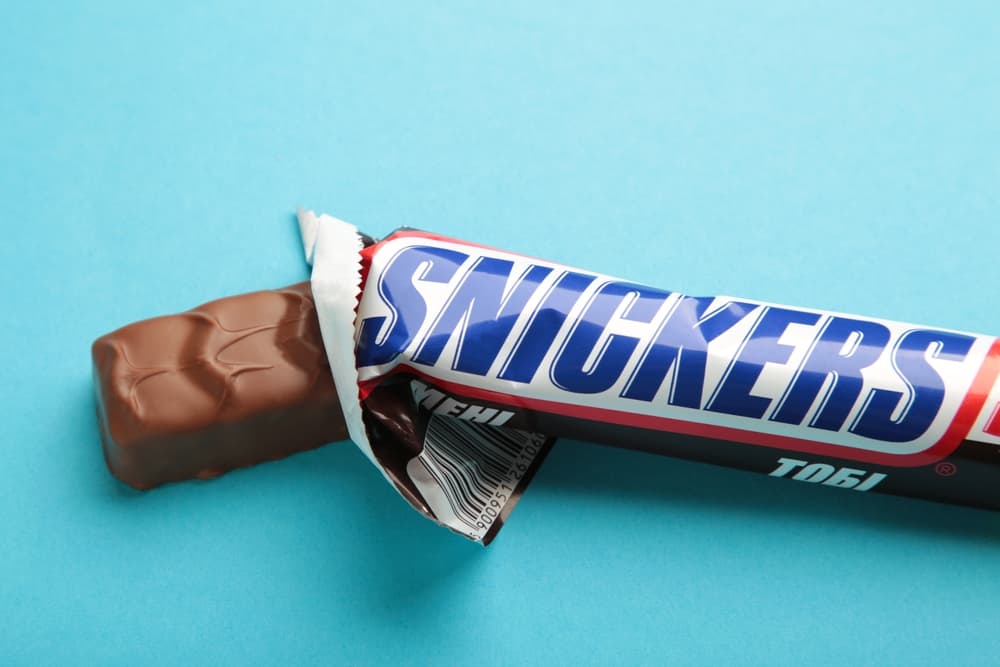 A snickers bar on a blue background.