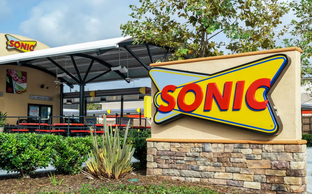A sonic restaurant with a sign in front of it.