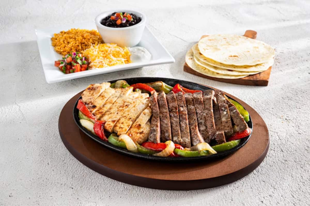 Grilled chicken and steak fajitas with sautéed peppers and onions, served with tortillas, Mexican rice, black beans, pico de gallo, cheese, and sour cream on the side—an option inspired by Chili’s gluten free menu for those seeking delicious flavor without compromise.