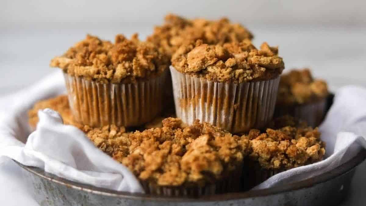 Apple crumb muffins in a bowl with a napkin.