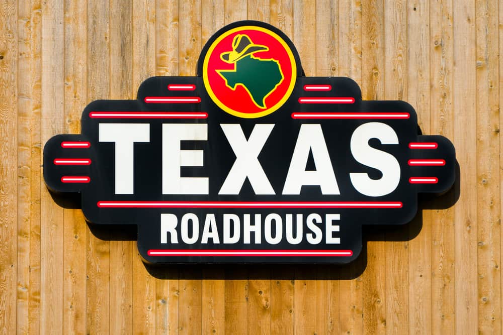 A wooden wall adorned with a sign for Texas Roadhouse.