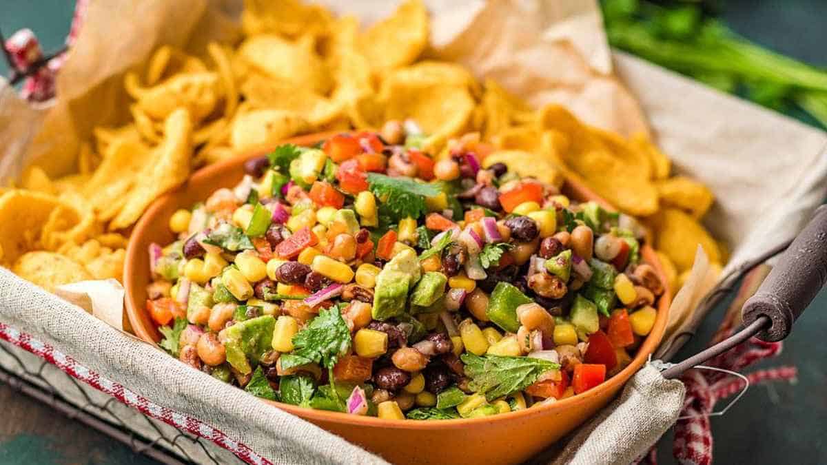 A bowl of black bean and corn salsa with tortilla chips.