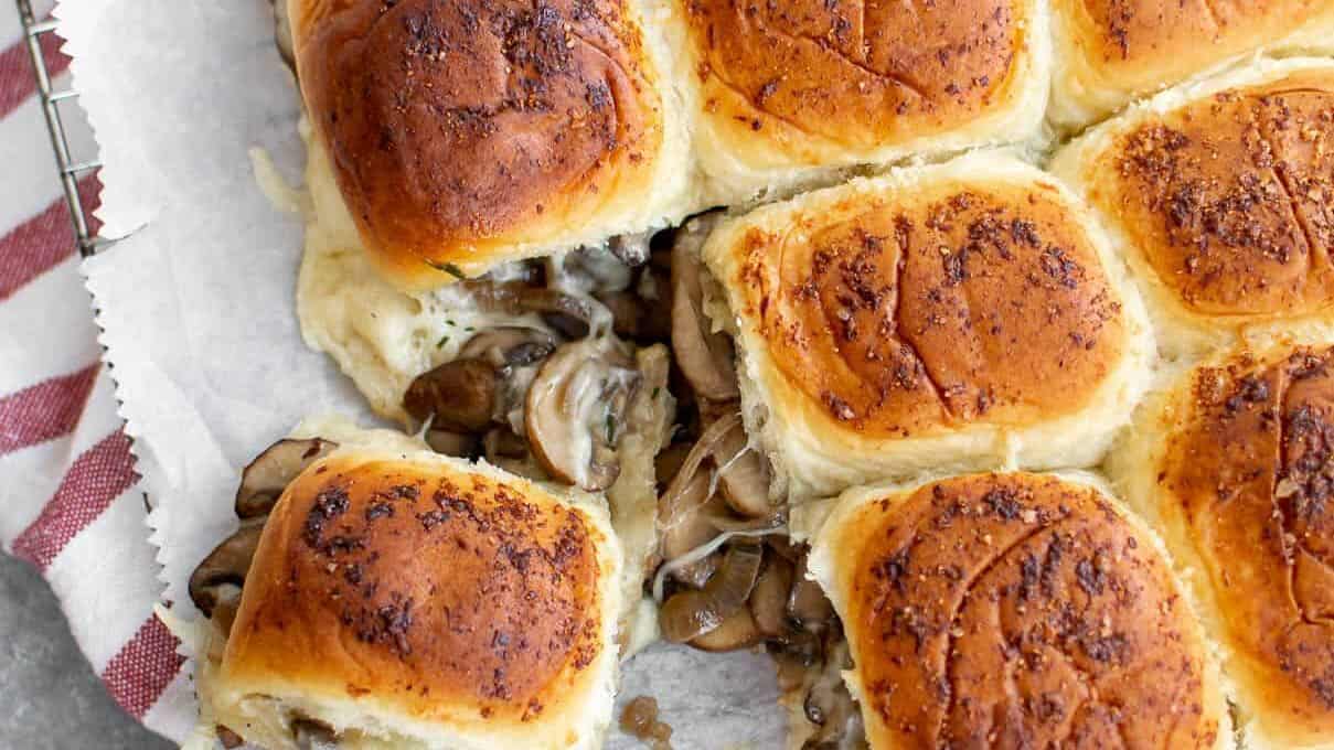 Mushroom and cheese sliders on a baking sheet.