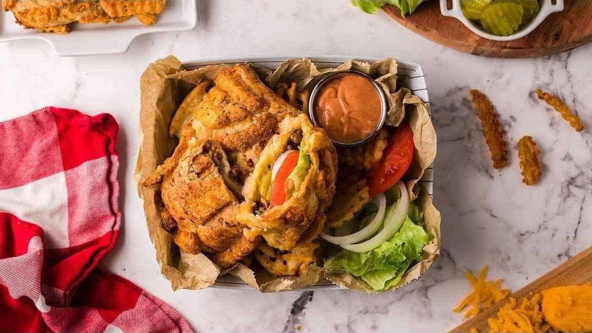 A tray of fried fish and vegetables on a table.