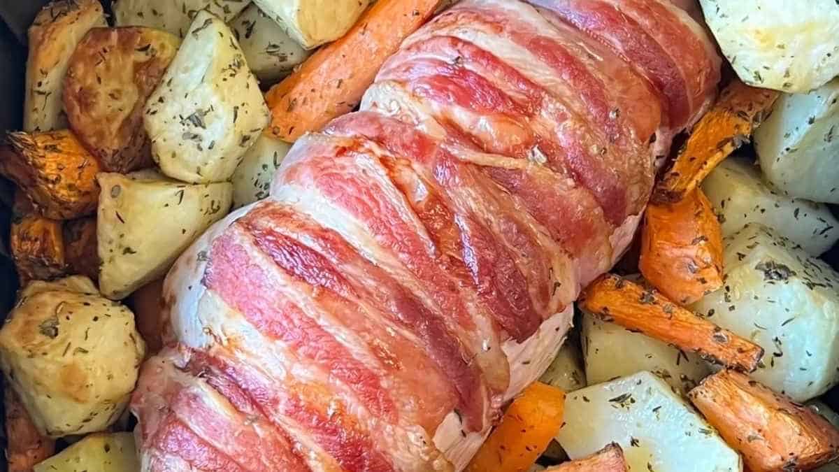 Bacon wrapped pork loin with carrots and potatoes.