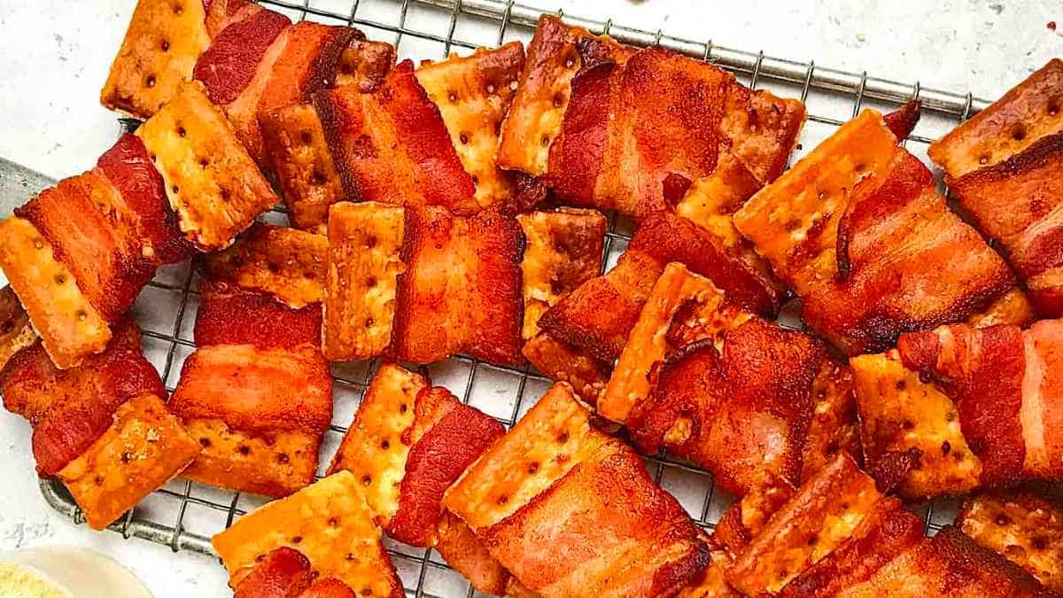 Bacon wrapped crackers on a cooling rack.