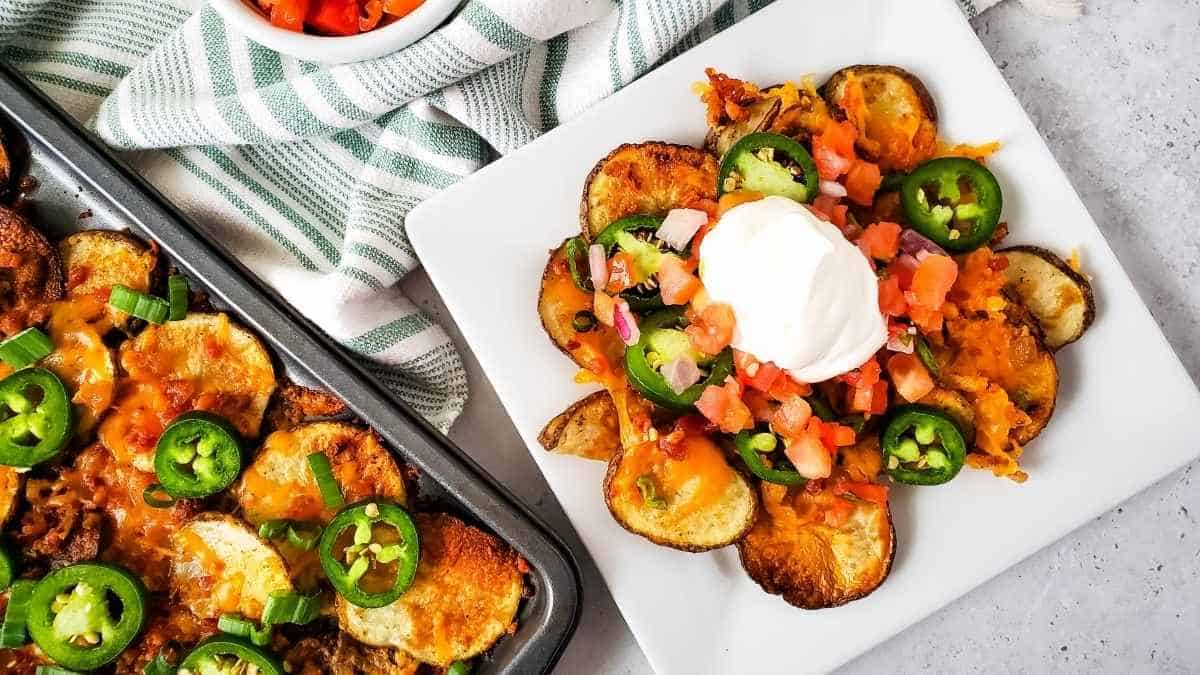 A plate of nachos with sour cream and jalapenos.