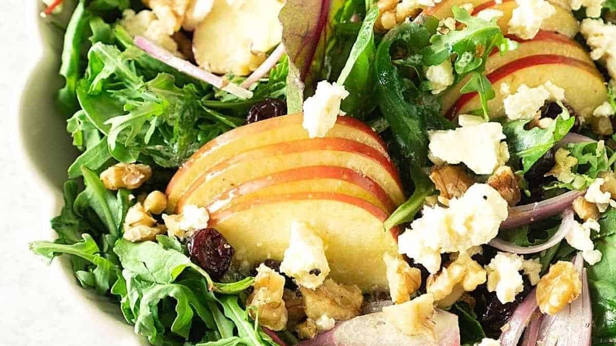 A salad with apples, cranberries and feta cheese.