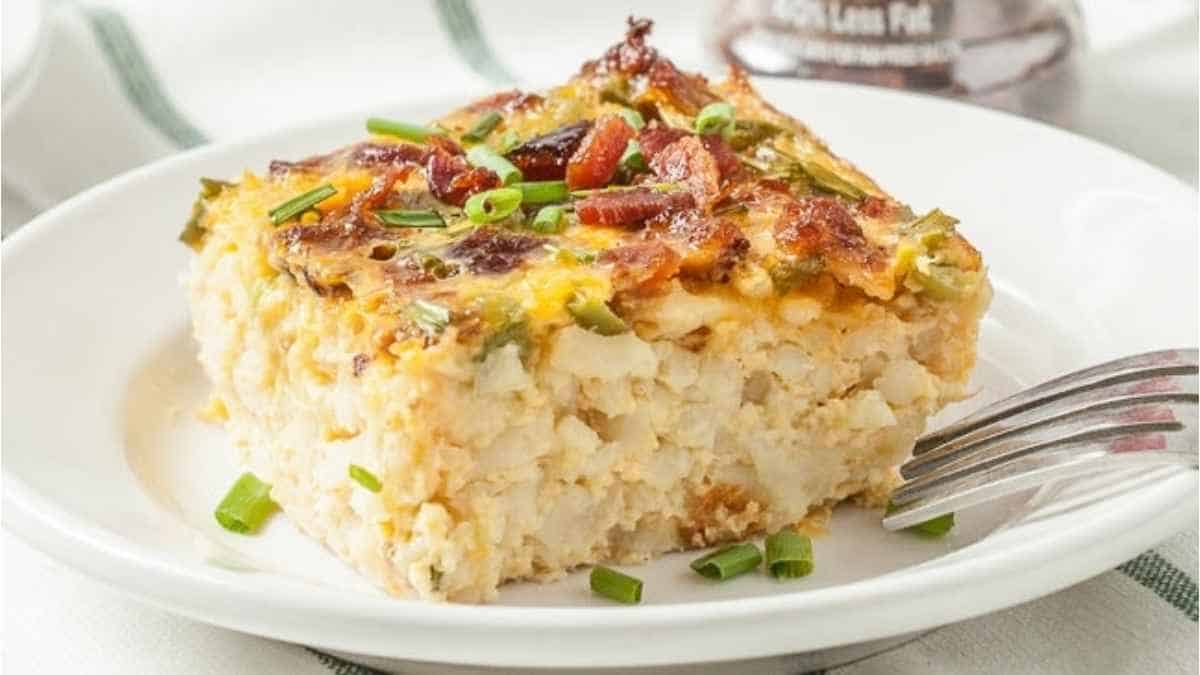 A slice of breakfast casserole on a plate with a fork.