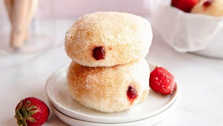 A stack of doughnuts with jam on top.