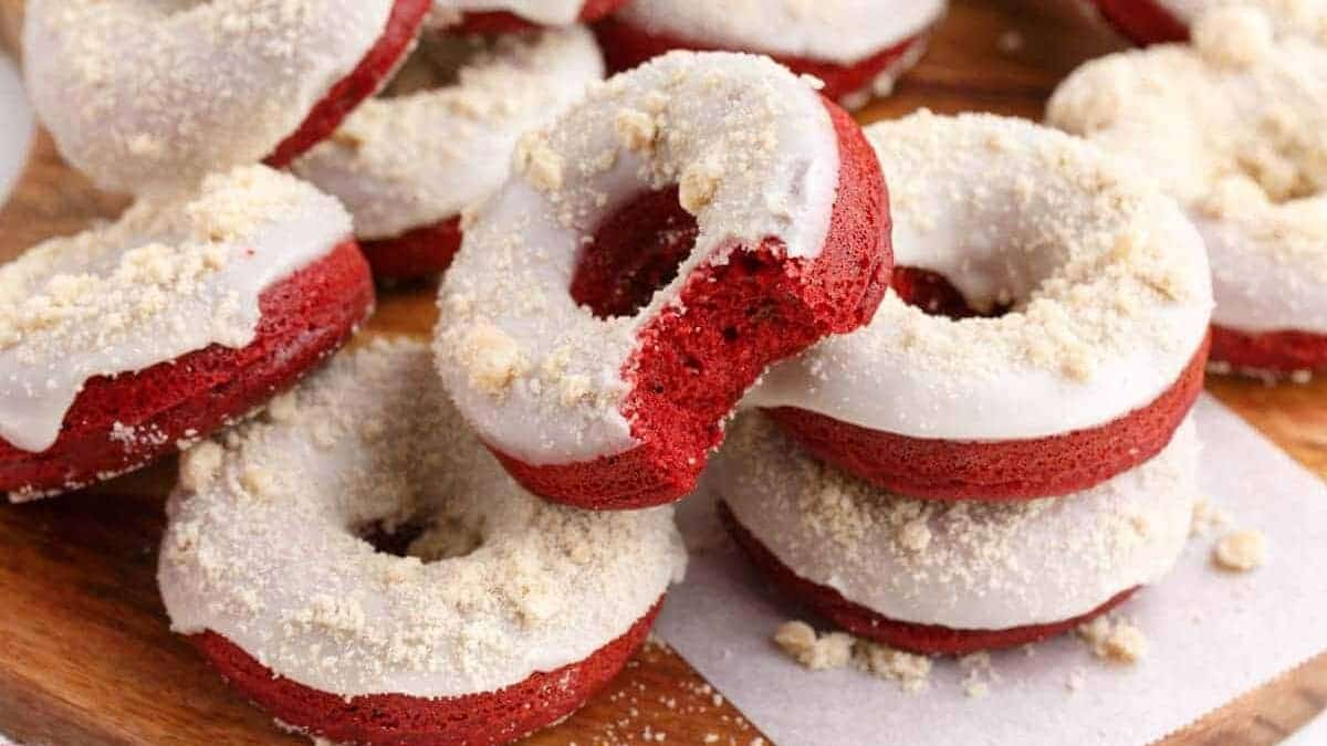 Red velvet donuts on a wooden cutting board.