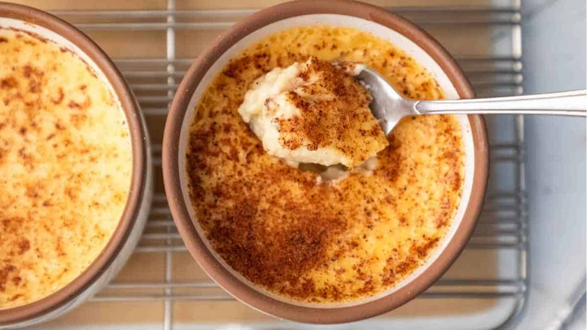 Two bowls of cheesy casserole with a spoon.