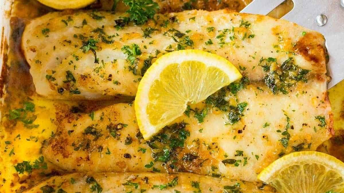 Fish fillets in a baking dish with lemon slices.