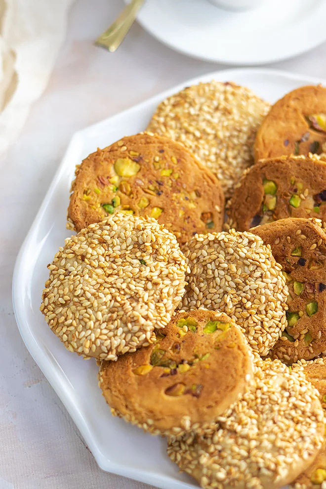 A unique plate of cookies with sesame seeds and pistachios.