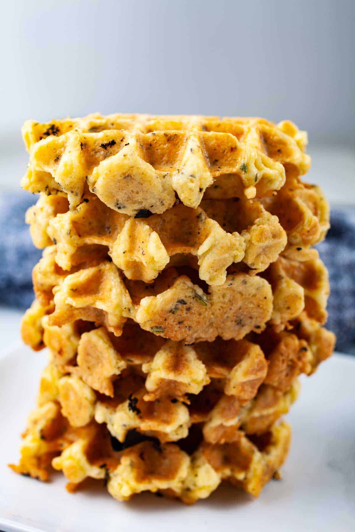 A stack of golden brown egg and cheese waffles. 
